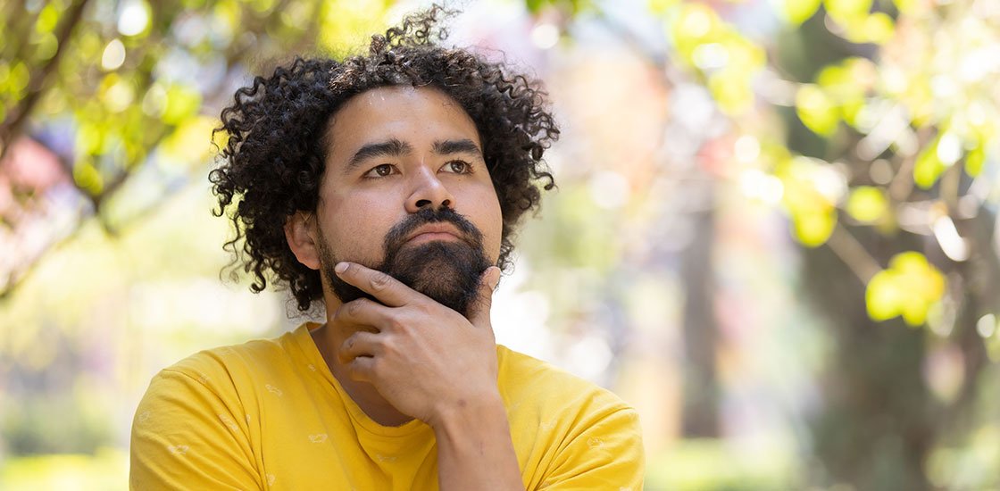 Man in a park thinking about buying cannabis in Port Credit, Mississauga, and Burlington, Ontario.