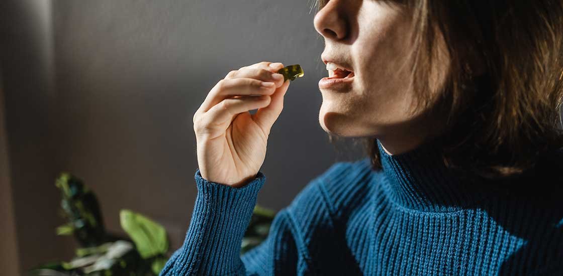 woman ready to eat a THC gummy from a cannabis store Burlington